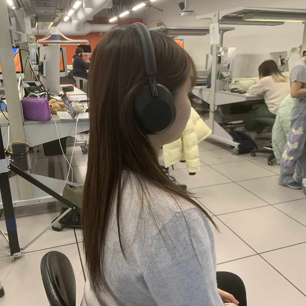 <b>Side Profile with Headphones</b><br>In this photo, you can see me from the side, still wearing the headphones. The headphones fit snugly around my ears, and I’m positioned looking ahead, indicating a moment of focus or deep listening.