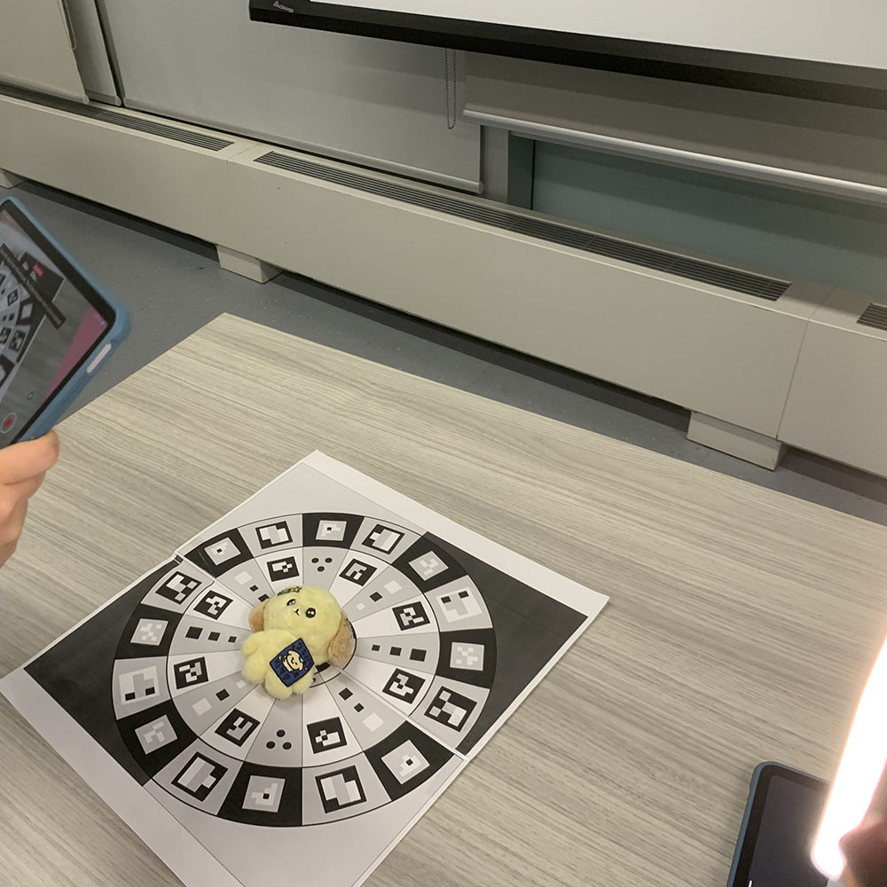 <b>Enhancing My 3D Scan</b><br>Here, I've set up a toy for scanning with additional lighting to ensure the 3D model captures all the details clearly. I use a smartphone and a fill light to optimize the scan quality.