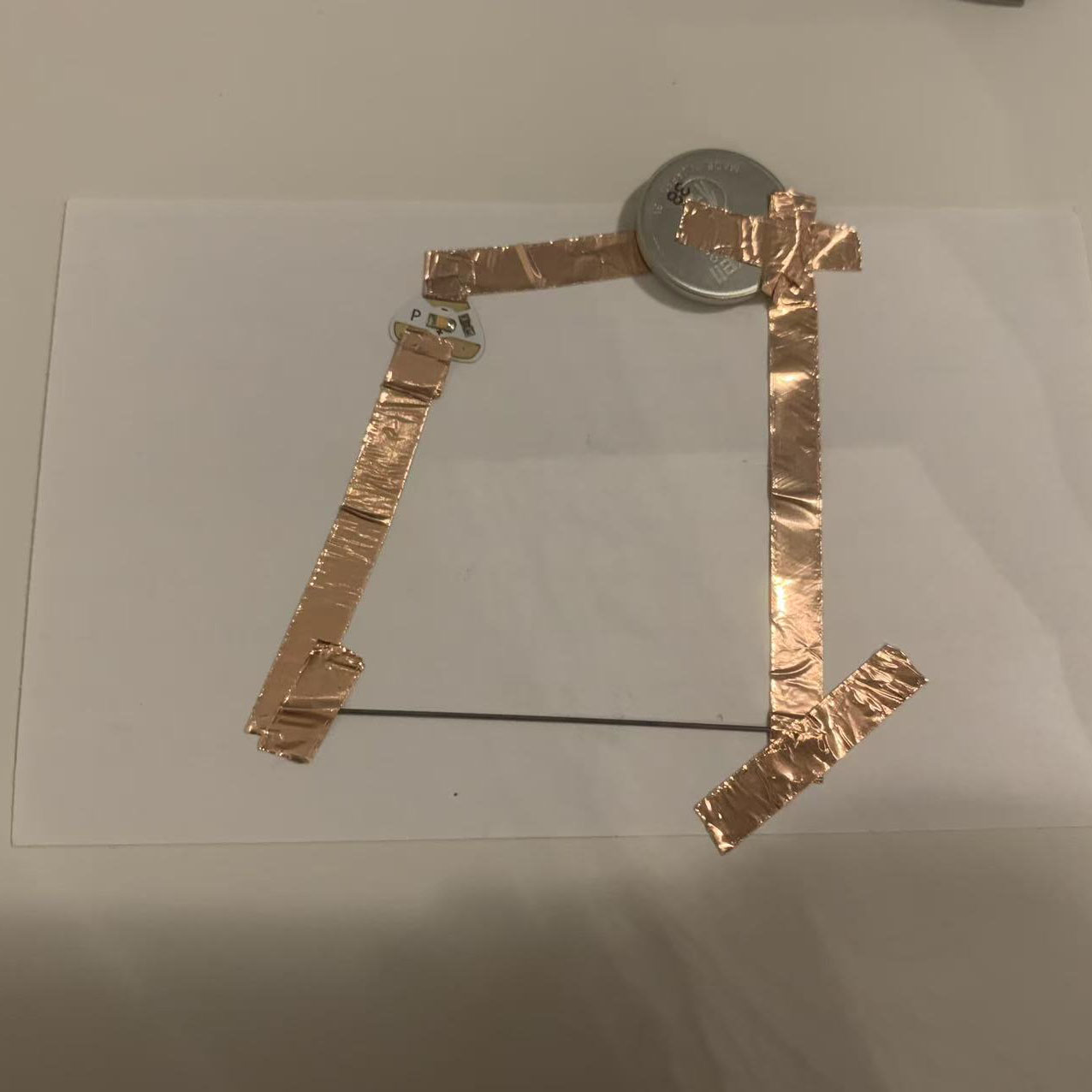 I constructed the circuit following my drawing. I used copper tape, a coin battery, and pencil lead to connect the components.