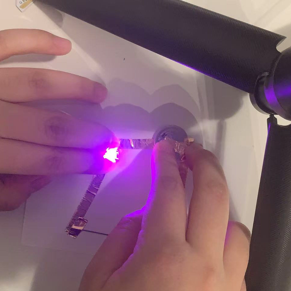 I pressed the components together, and the light turned on with a purple glow. It confirmed that the pencil lead works as a conductor.