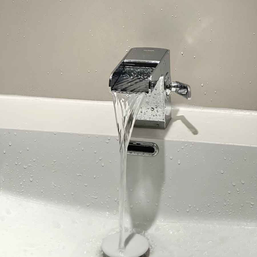 Water flowing from a modern faucet into a sink, showing the sound of water splashing and flowing during hand washing.