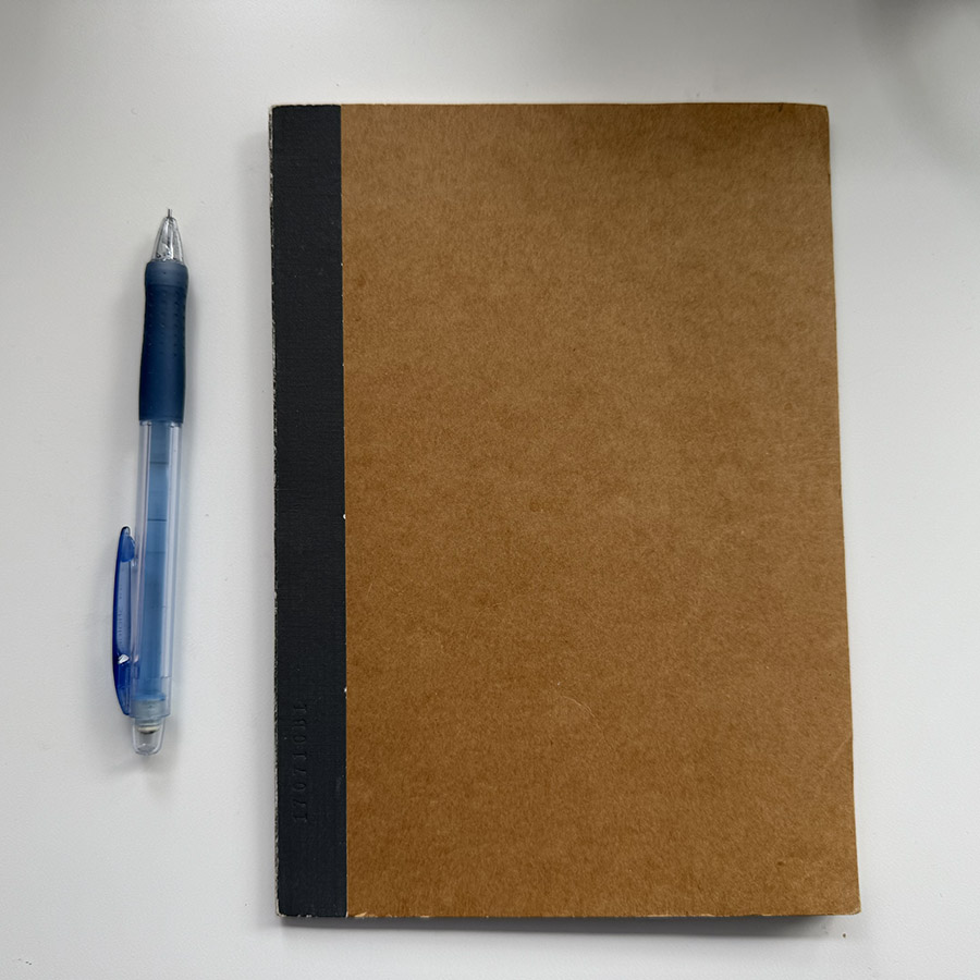 A notebook with a blue pen on top, depicting the sound of a pencil writing on paper.