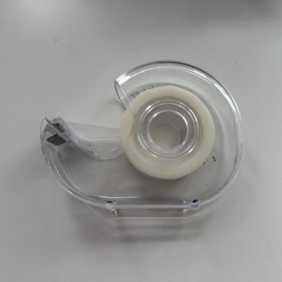 A tape dispenser with a clear roll of tape, representing the sticky sound as tape is pulled and torn off.