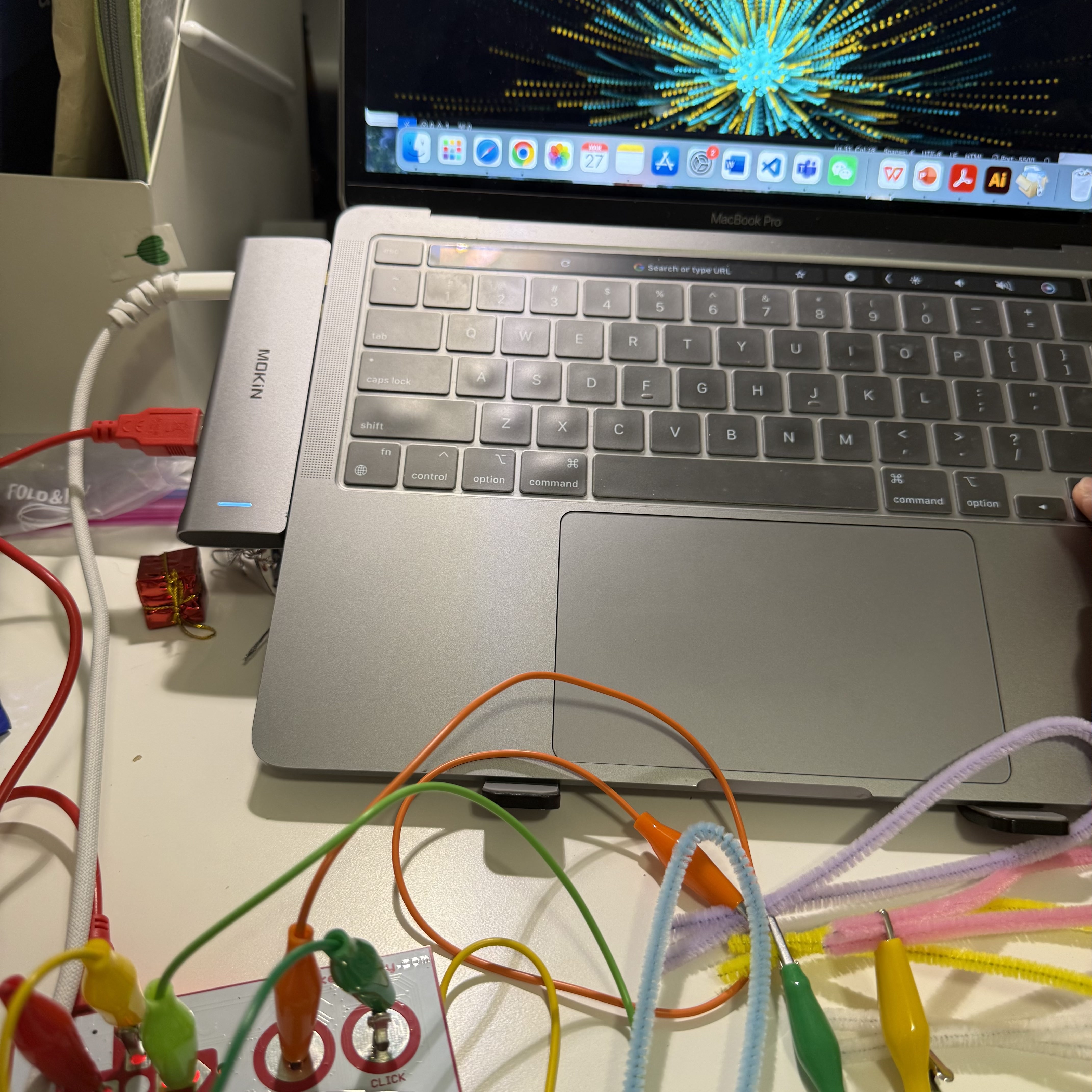 In this view, my laptop screen displays vibrant, animated graphics that react to my inputs from the pipe cleaners. This makes my interaction with the computer screen both visually appealing and engaging, bringing a simple touch interface to life.